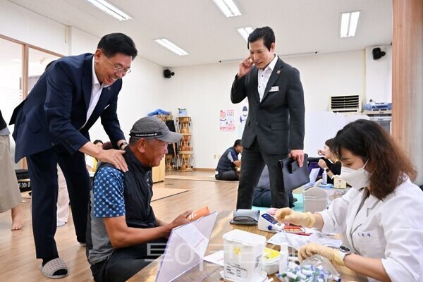 찾아가는 이동보건소에서 전진선 군수가 어르신을 안마하고 있다/투어코리아뉴스 정명달 기자